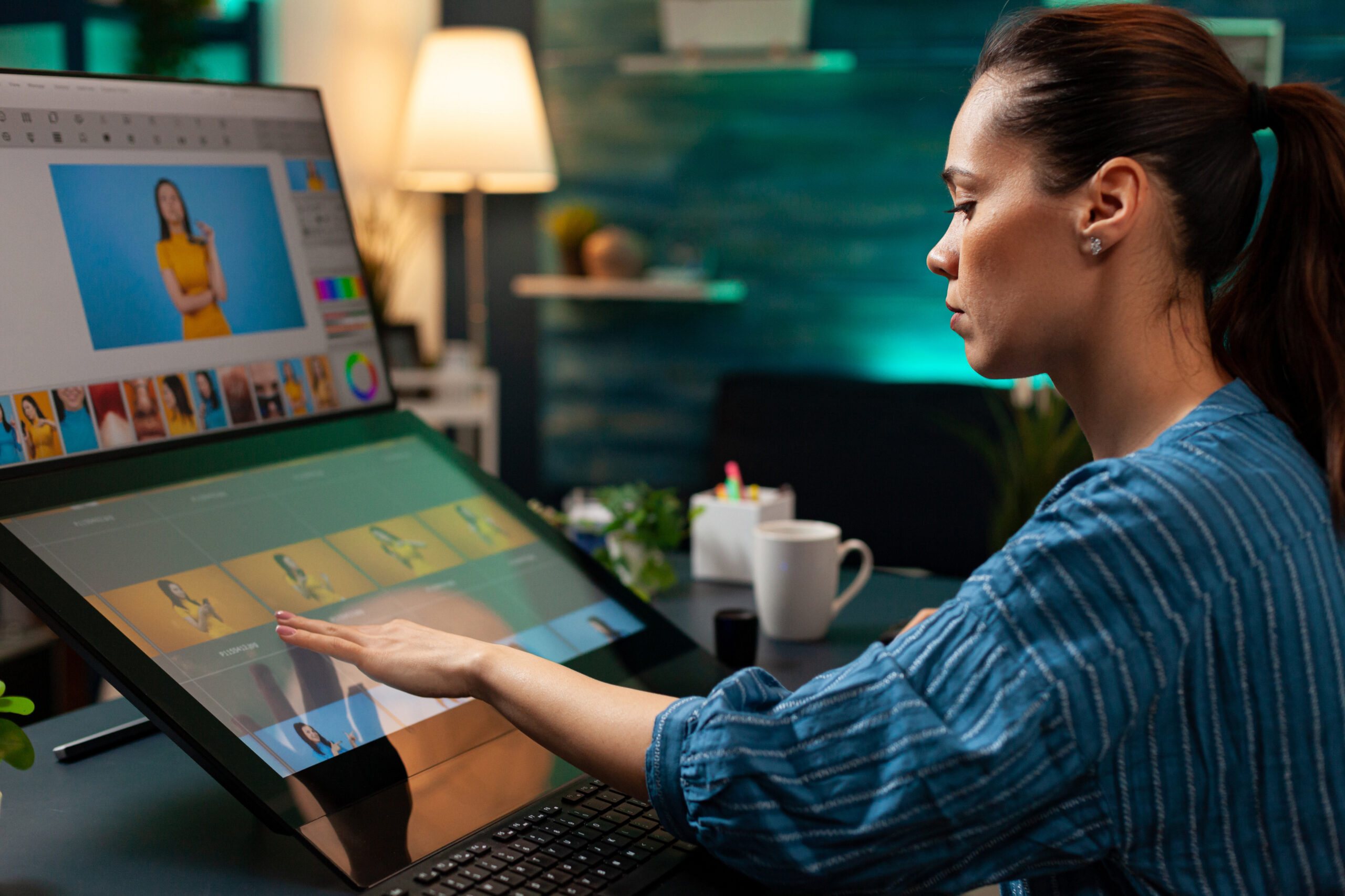 Professional editor doing retouching work on image for design project at office. Graphic artist woman working with touchpad monitor computer and modern digital production equipment